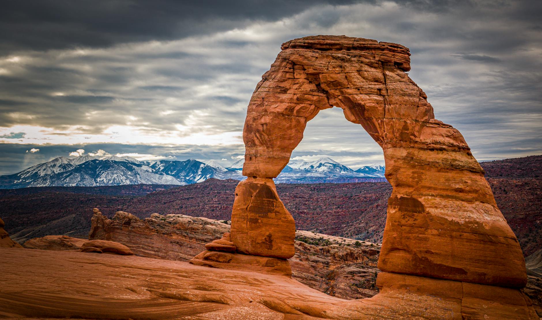 Capture of the iconic Delicate Arch in Utah, framed by a dramatic cloudy sky.