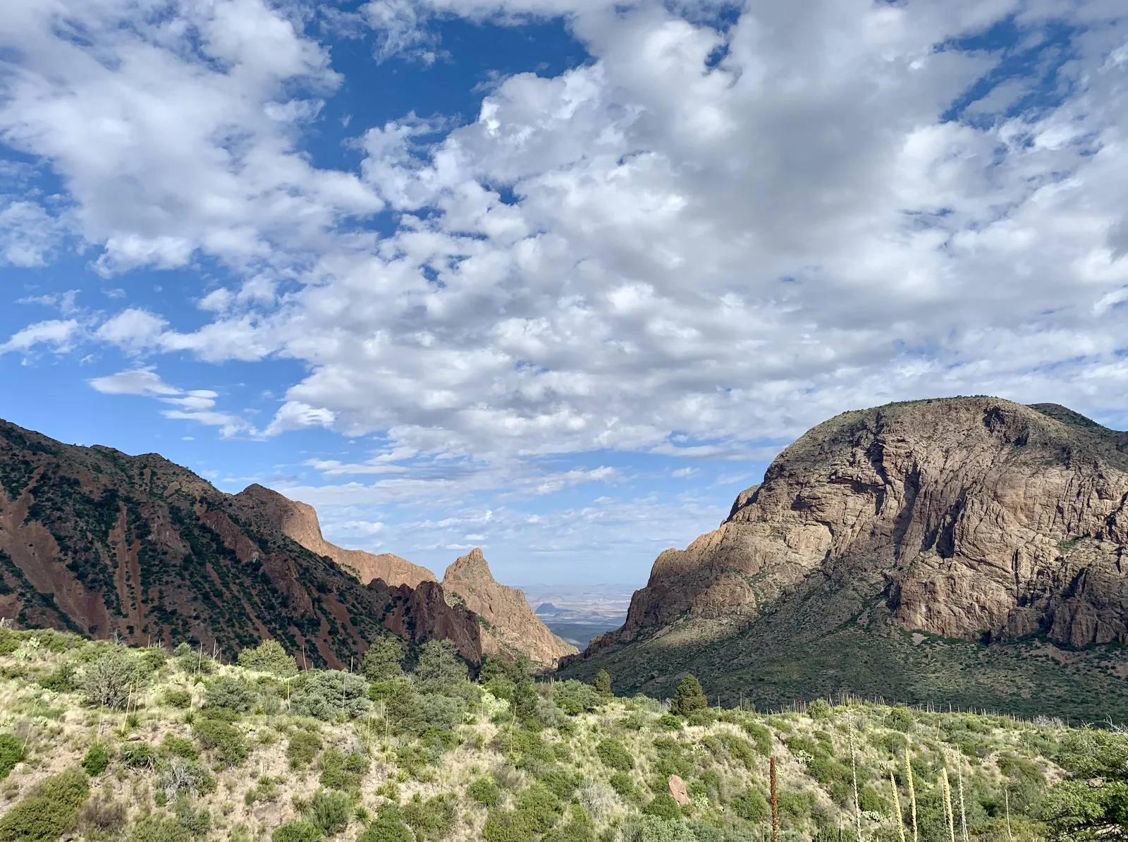 Several mountain peaks frame a "V" that is the lowest point in the Chisos Mountains.