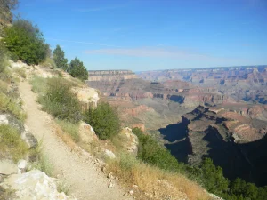 A rocky trail leads down into the depths of Grand Canyon along the side of a steep slope.