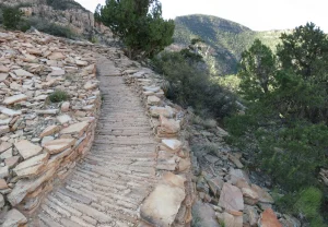 A trail constructed of meticulously placed slabs of rock winds its way down into Grand Canyon.