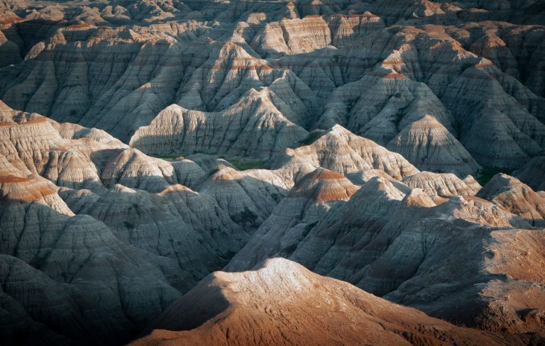 Stunning view of the rugged Badlands terrain, showcasing dramatic rock formations at sunset.