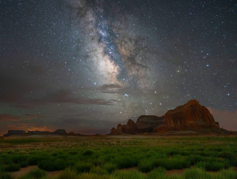 Mesmerizing view of the Milky Way galaxy stretching across the night sky over a desert landscape.