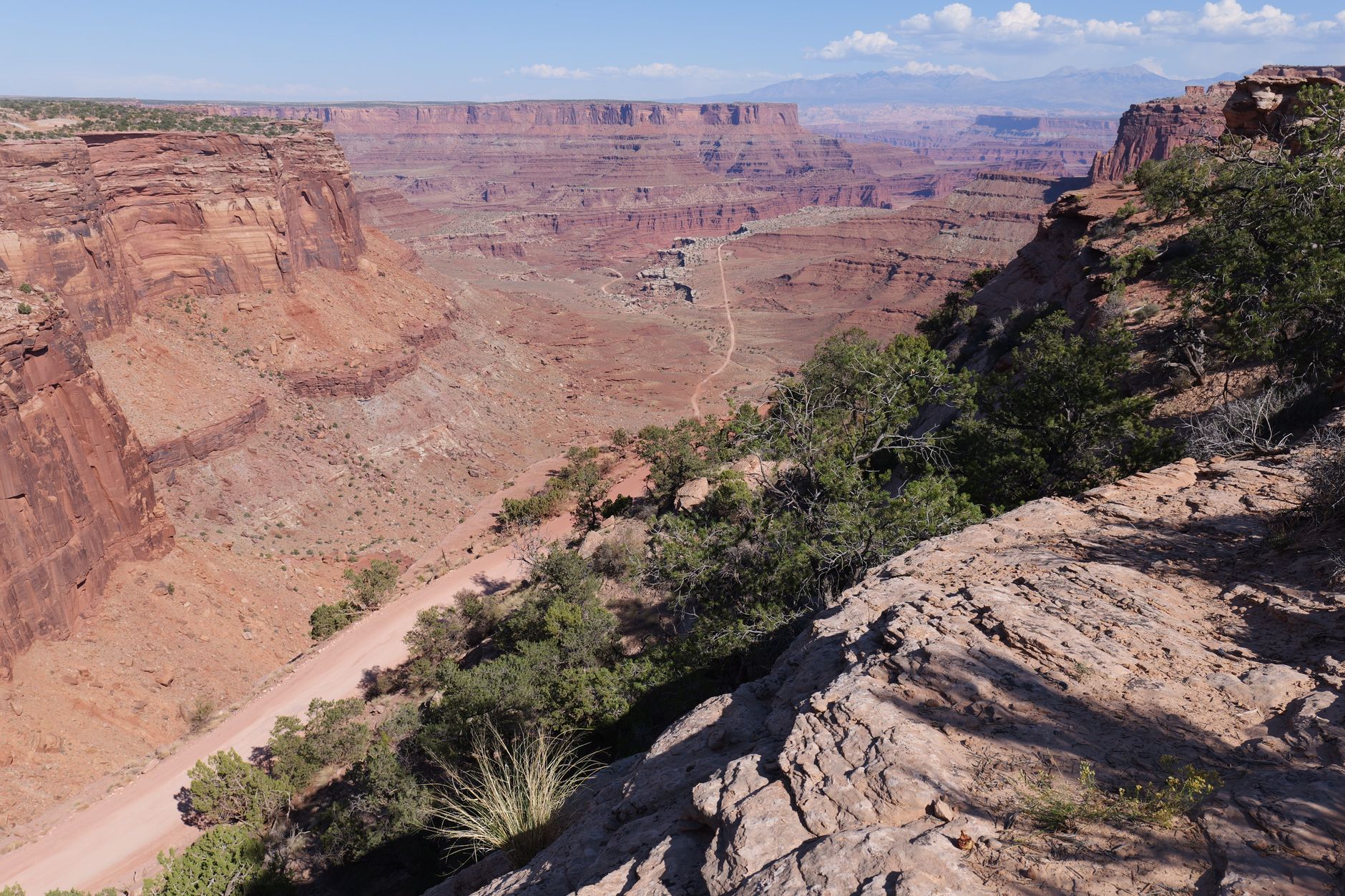 Breathtaking view of a canyon landscape showcasing layers of red rock under a clear blue sky.