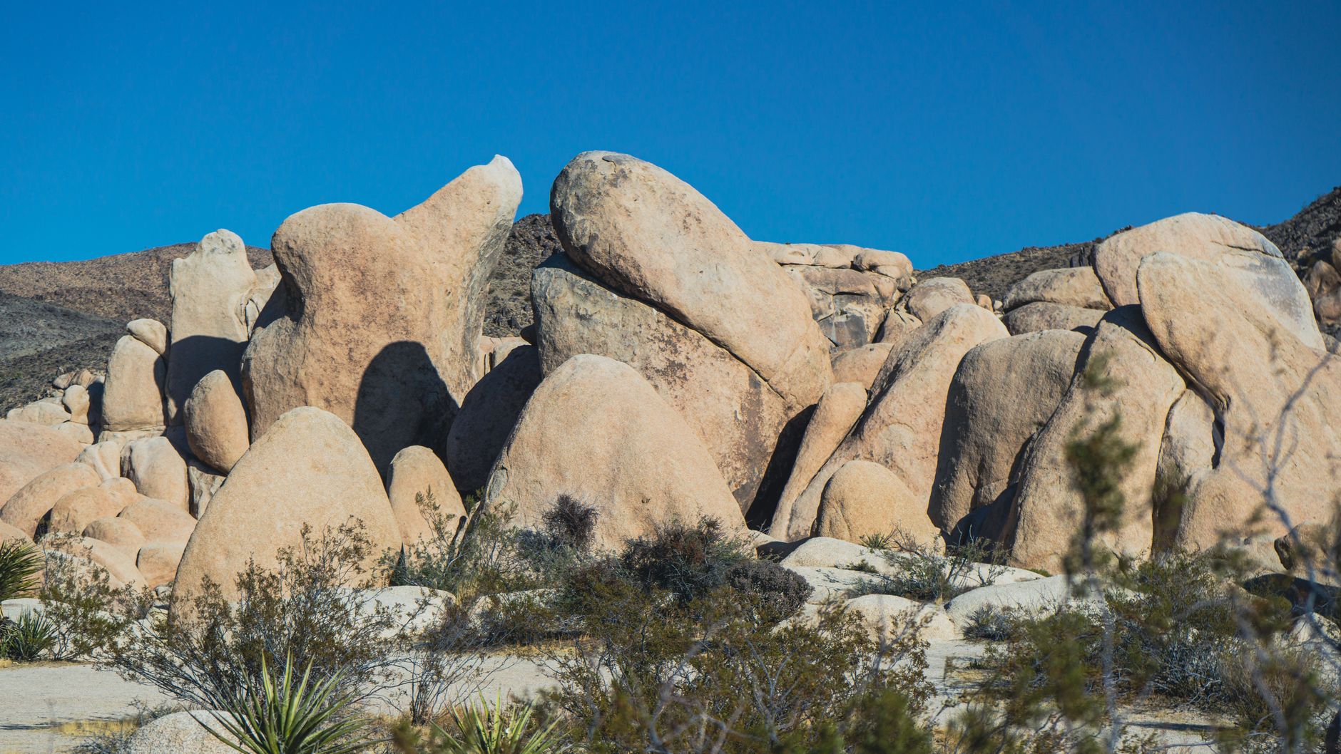 Stunning rock formations under a clear blue sky in Joshua Tree National Park, USA.