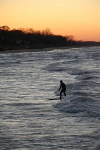 Surfer rides the waves at Portage Lakefront and Riverwalk at the Indiana Dunes National Park.