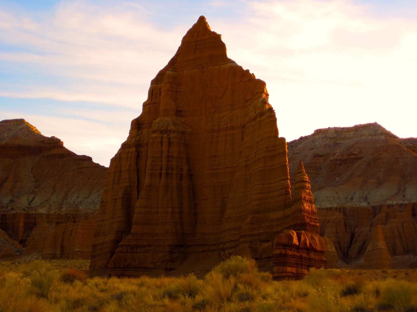 Stunning view of rock formations at sunset in Utah's desert, capturing the vibrant colors and unique geological features.