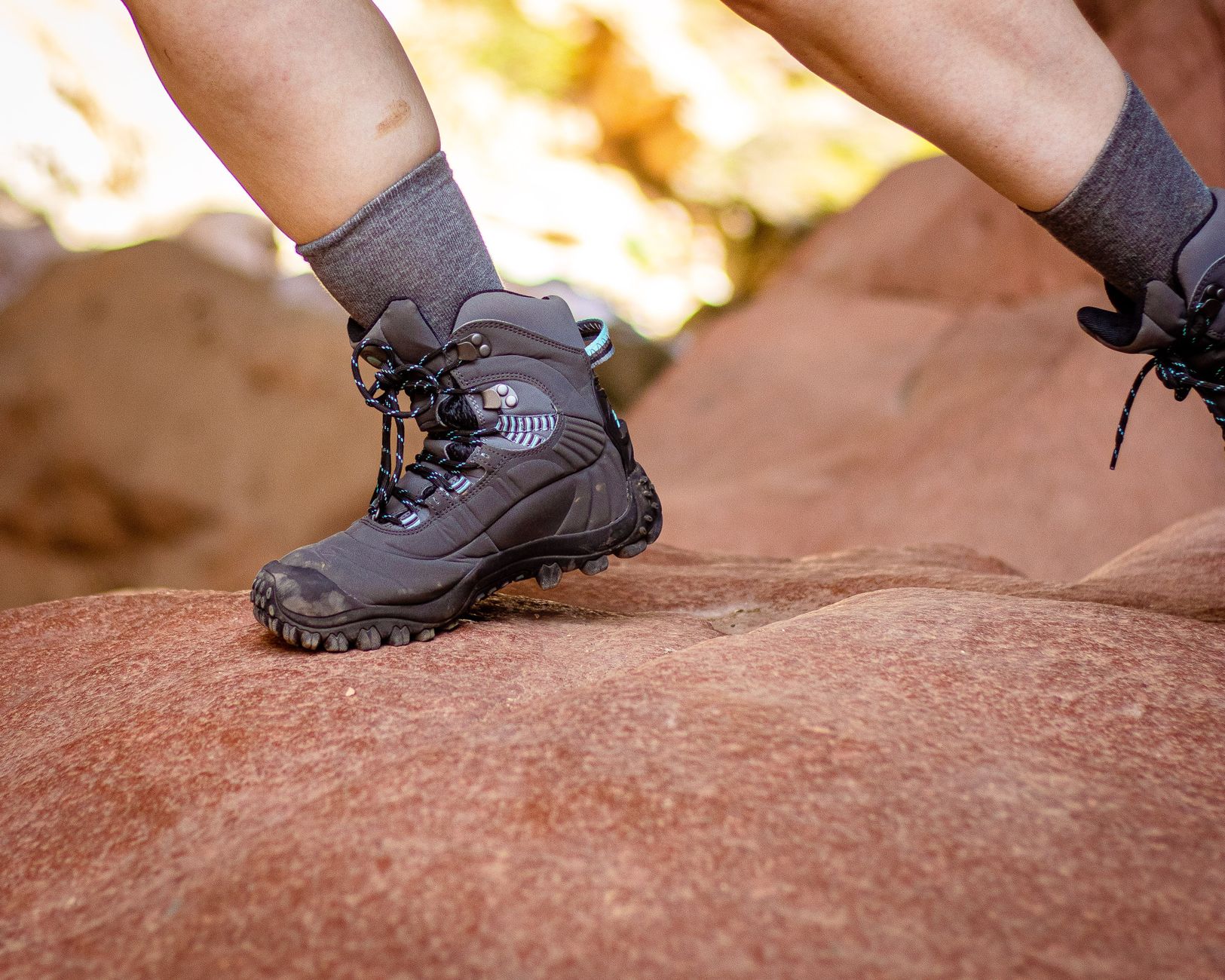 Close-up of hiking boots on a rocky trail, emphasizing outdoor adventure.