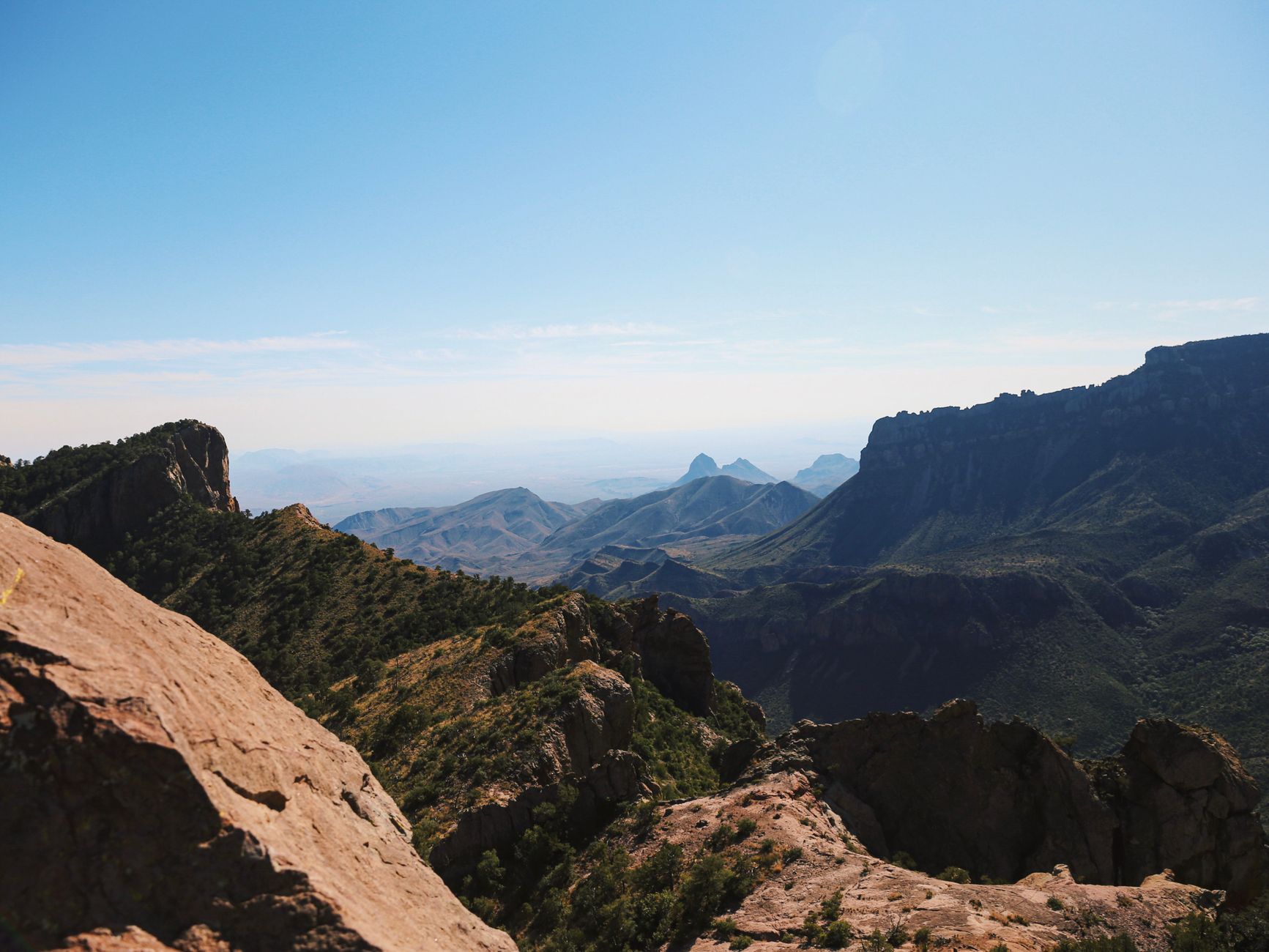 Capture the breathtaking views of Big Bend National Park's rugged mountain terrain under a clear blue sky.