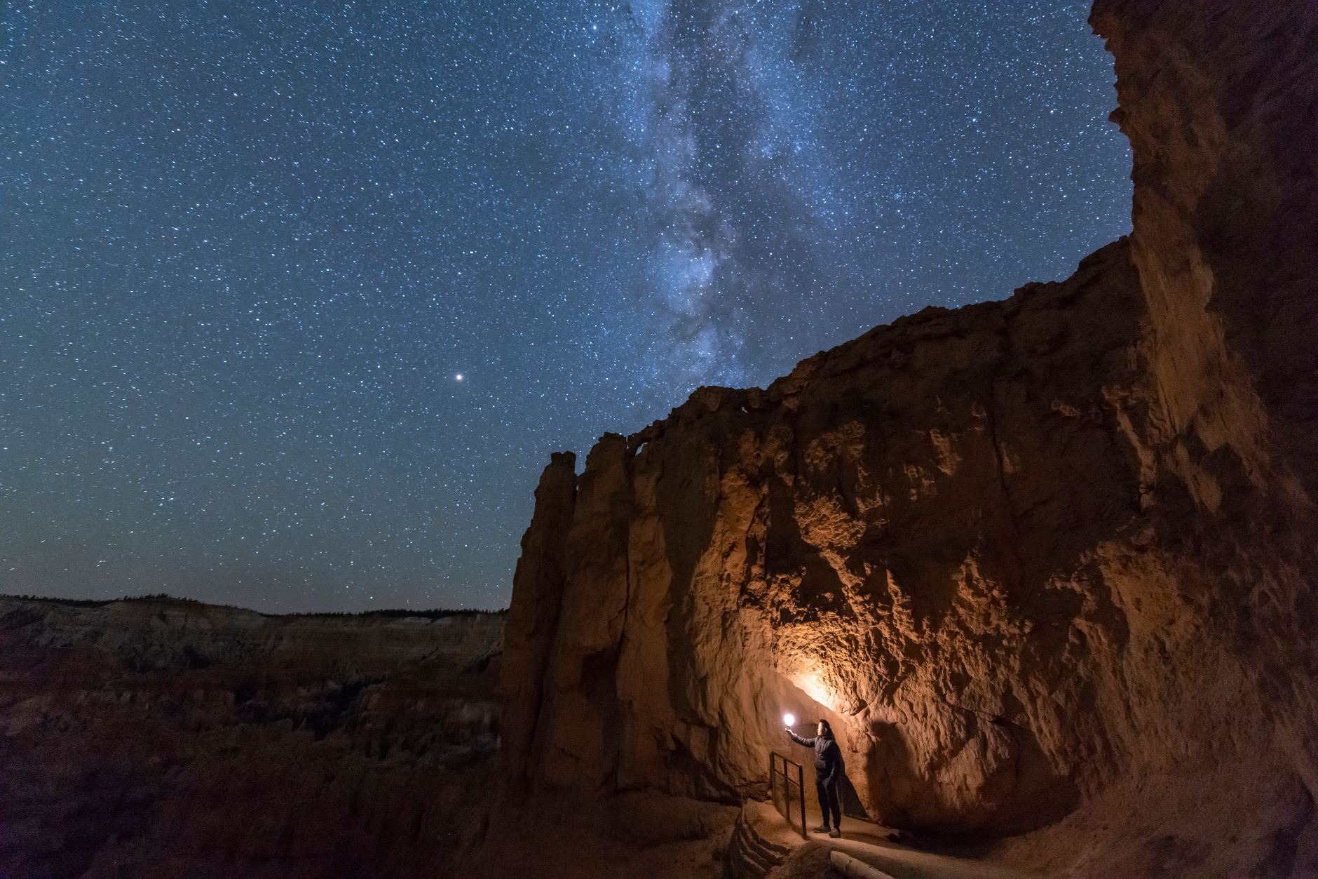 A starry night in Bryce Canyon National Park, Utah with the Milky Way above a rocky landscape.