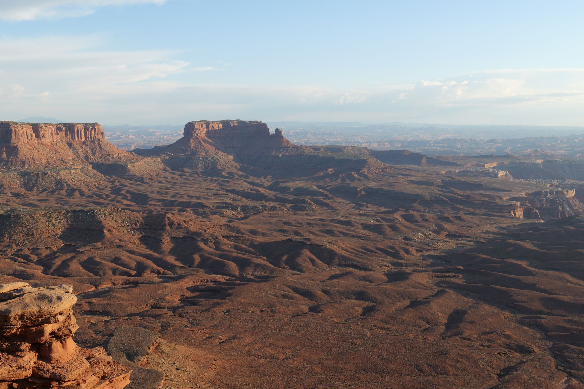 Expansive view of the rugged Canyonlands National Park landscape under a bright blue sky.
