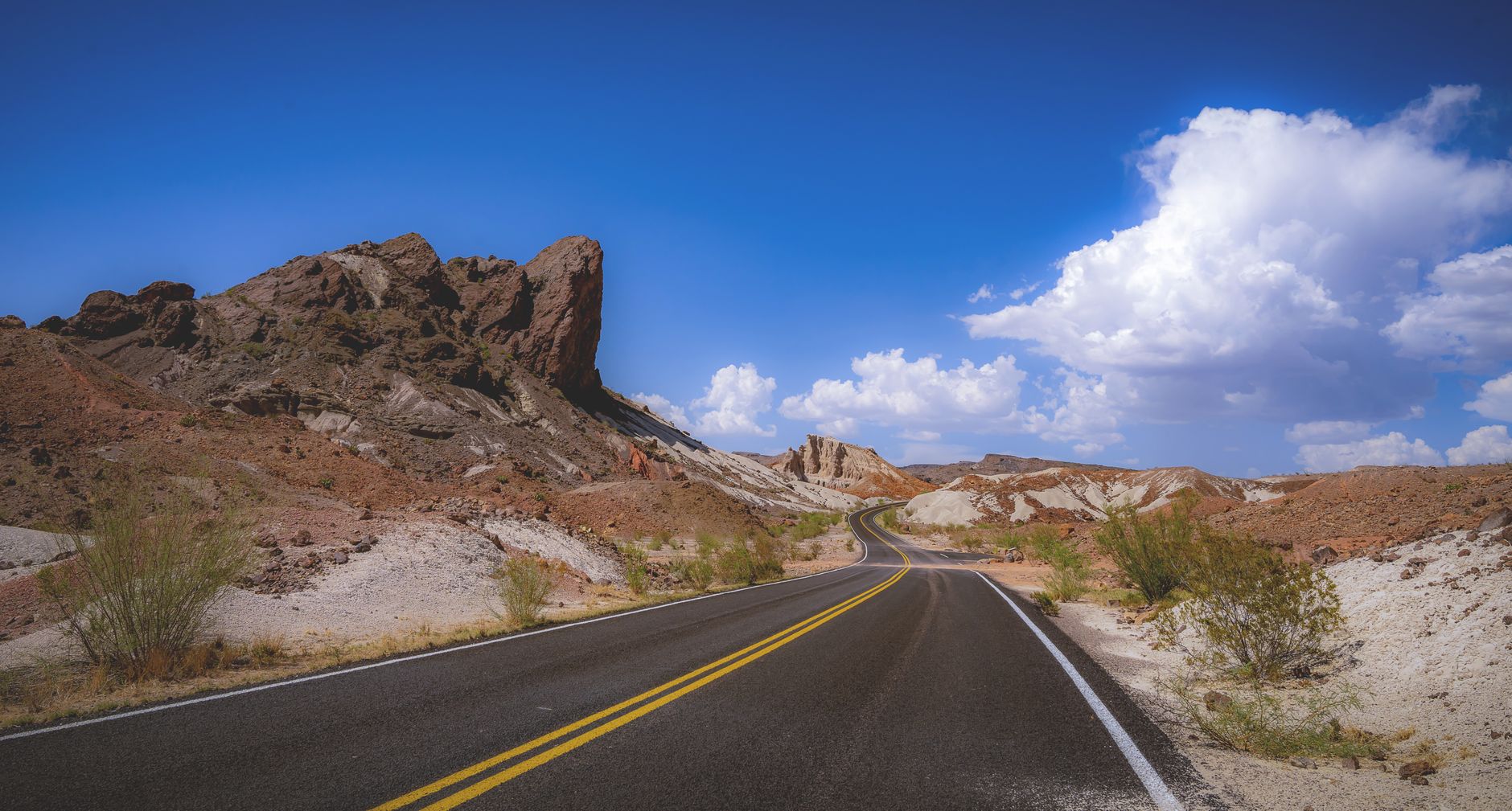 A winding road under a clear blue sky in Big Bend National Park, Texas.