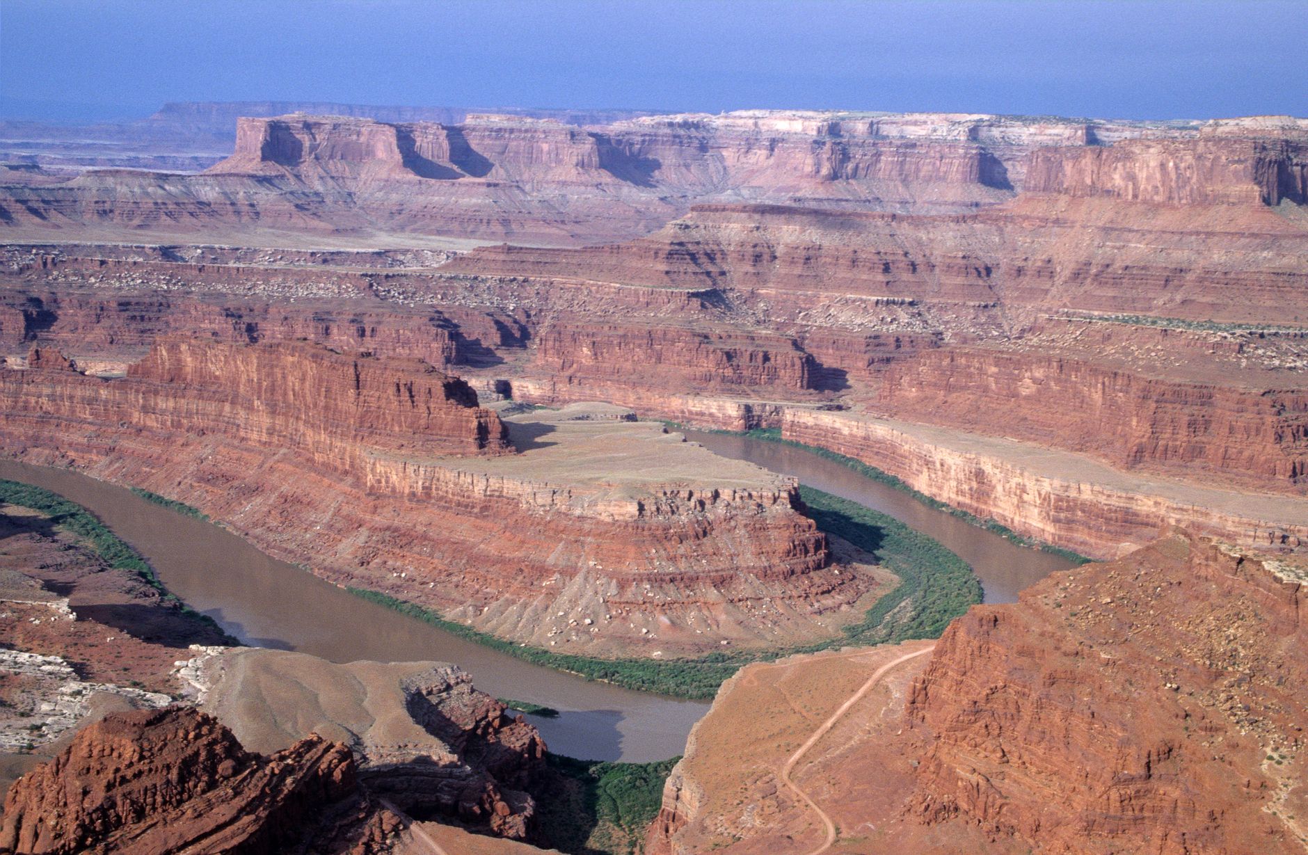 A stunning aerial view of Utah's canyon landscape, showcasing winding rivers and rugged cliffs.