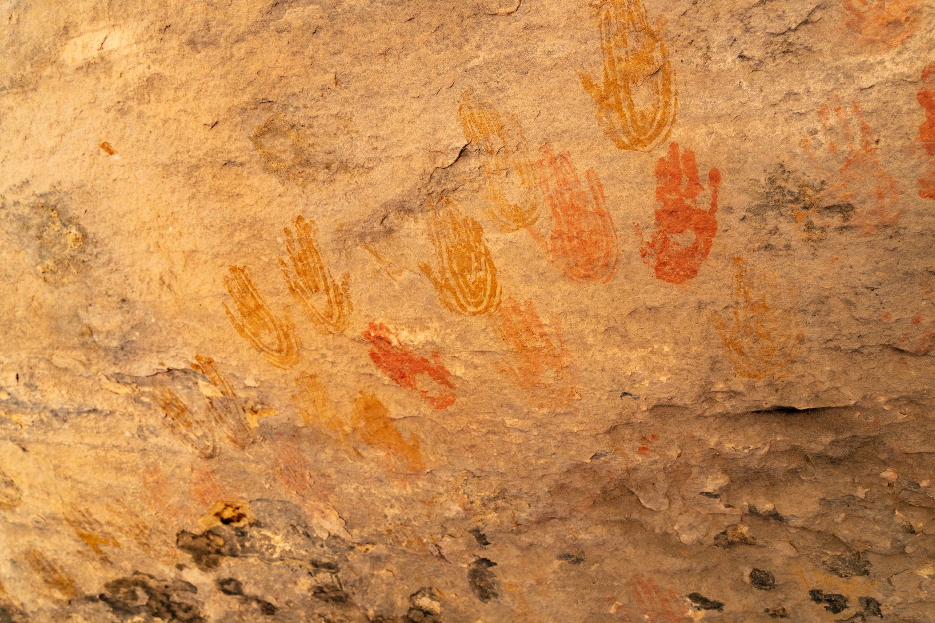 Close-up of ancient handprints on a canyon wall, symbolizing native art in Utah.