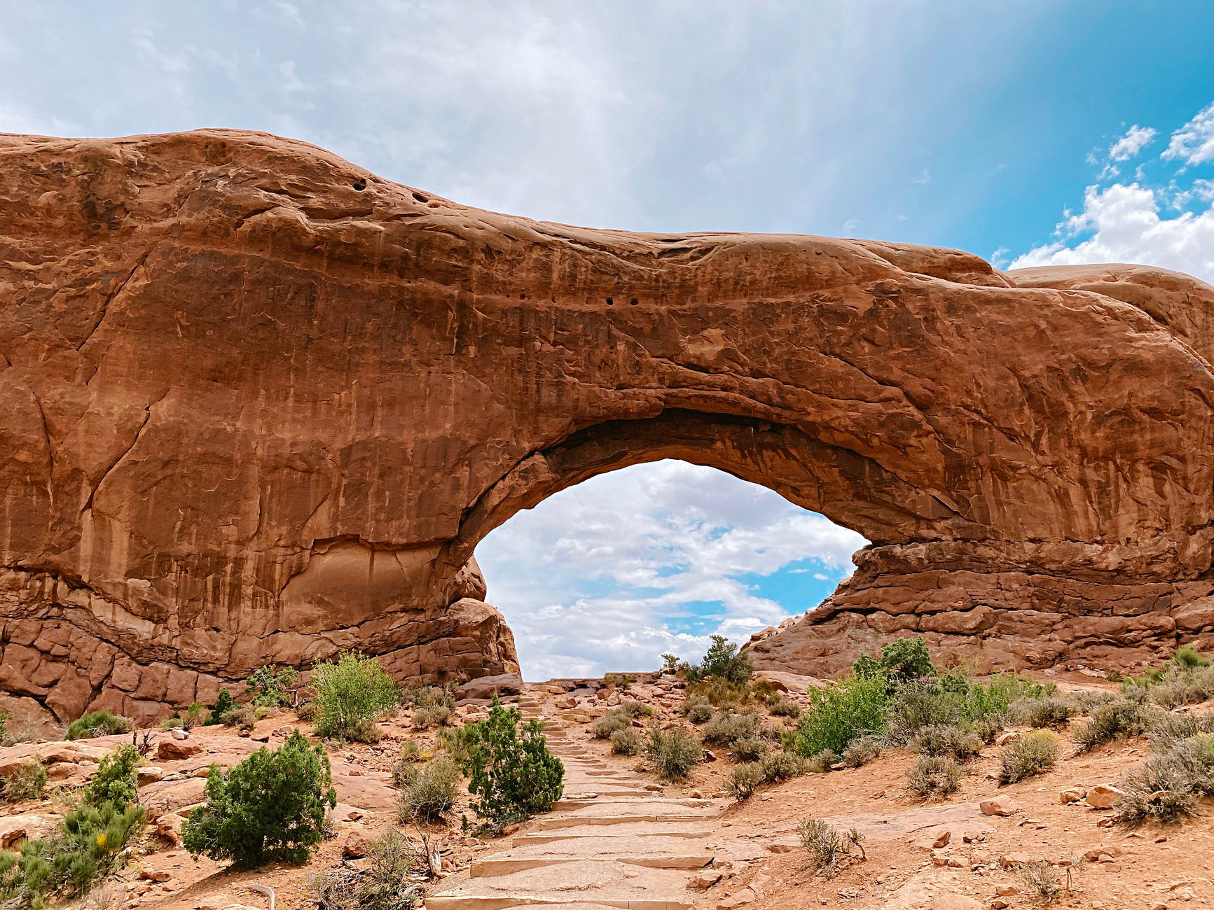 Breathtaking view of North Window Arch in Utah's Arches National Park on a sunny day.