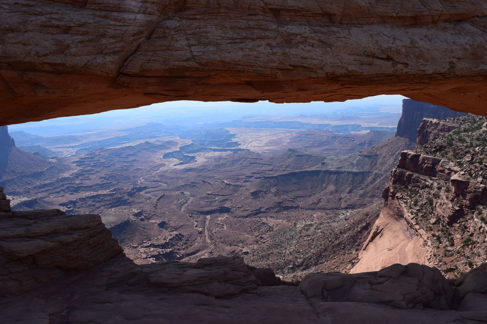Stunning view of Canyonlands framed by the Mesa Arch, showcasing unique geological formations.