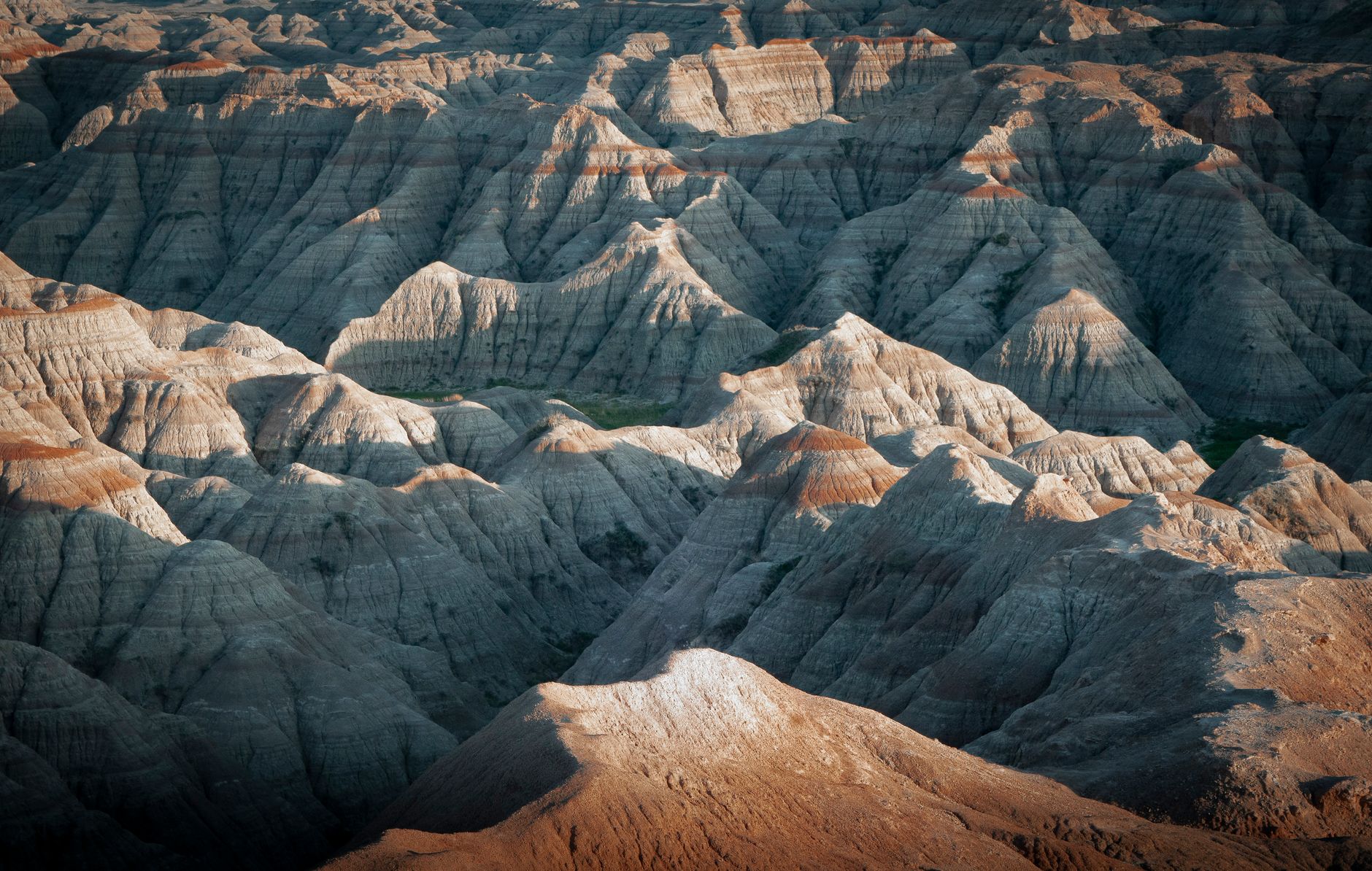 Stunning view of the rugged Badlands terrain, showcasing dramatic rock formations at sunset.