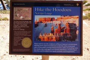 A wayside showing a tall red rock spire describes hoodoos and the Hike the Hoodoos program
