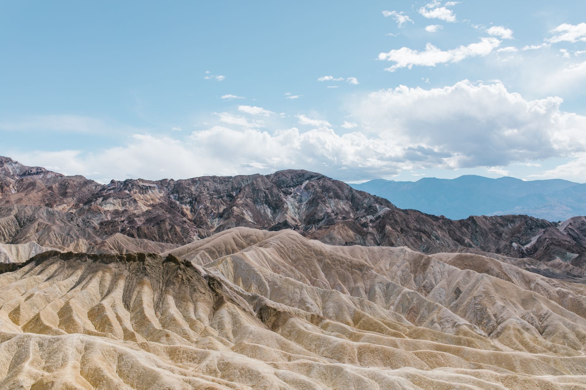 A breathtaking view of rocky hills in an arid desert landscape under a blue sky.