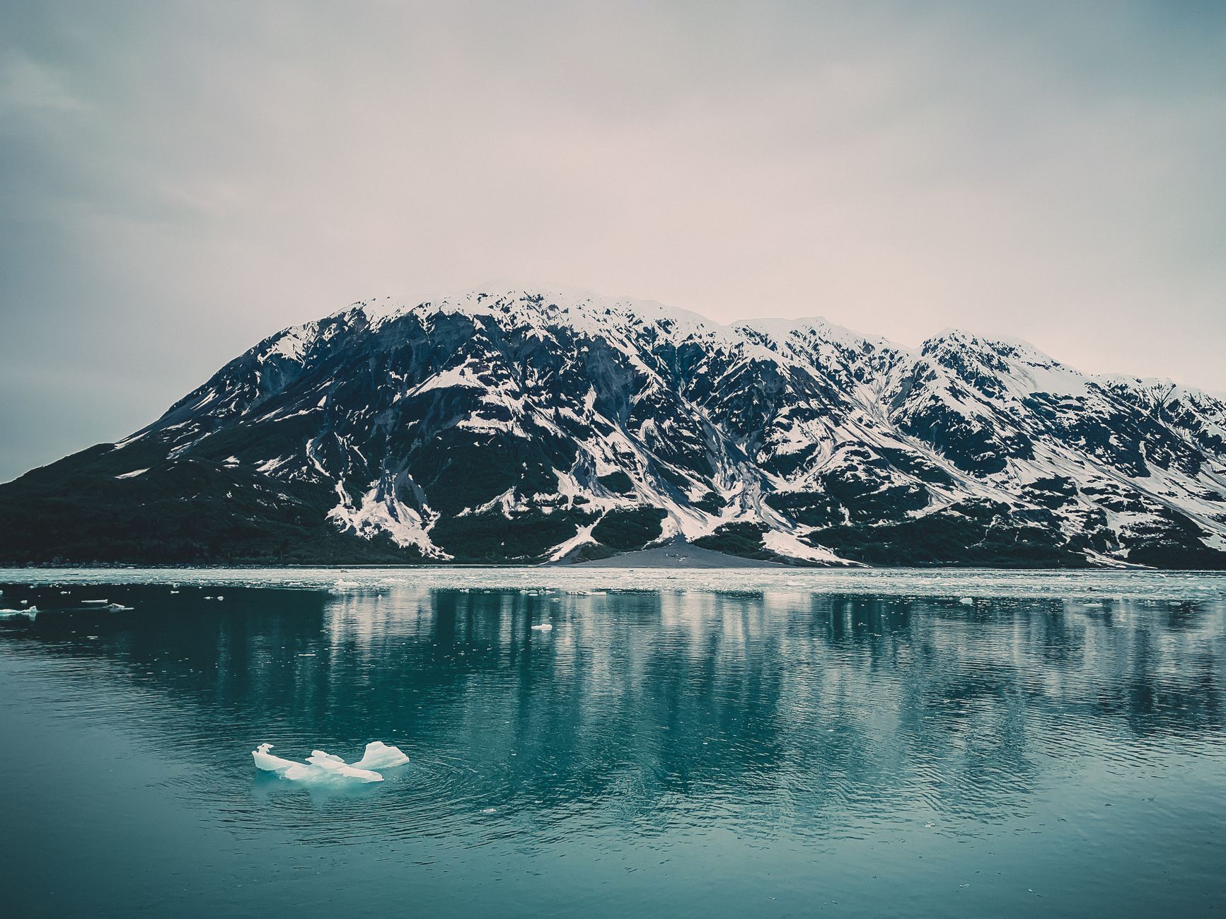 A breathtaking view of a snowcapped mountain reflected in a tranquil lake, showcasing nature's beauty.
