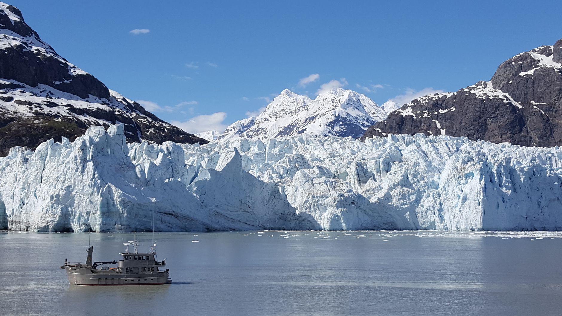 Stunning view of a glacier in Alaska, featuring ice-capped mountains and a serene ocean scene.