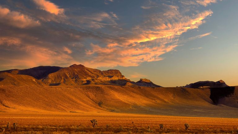 Capture the vibrant hues and dramatic skies of Nevada's desert landscape at sunset.