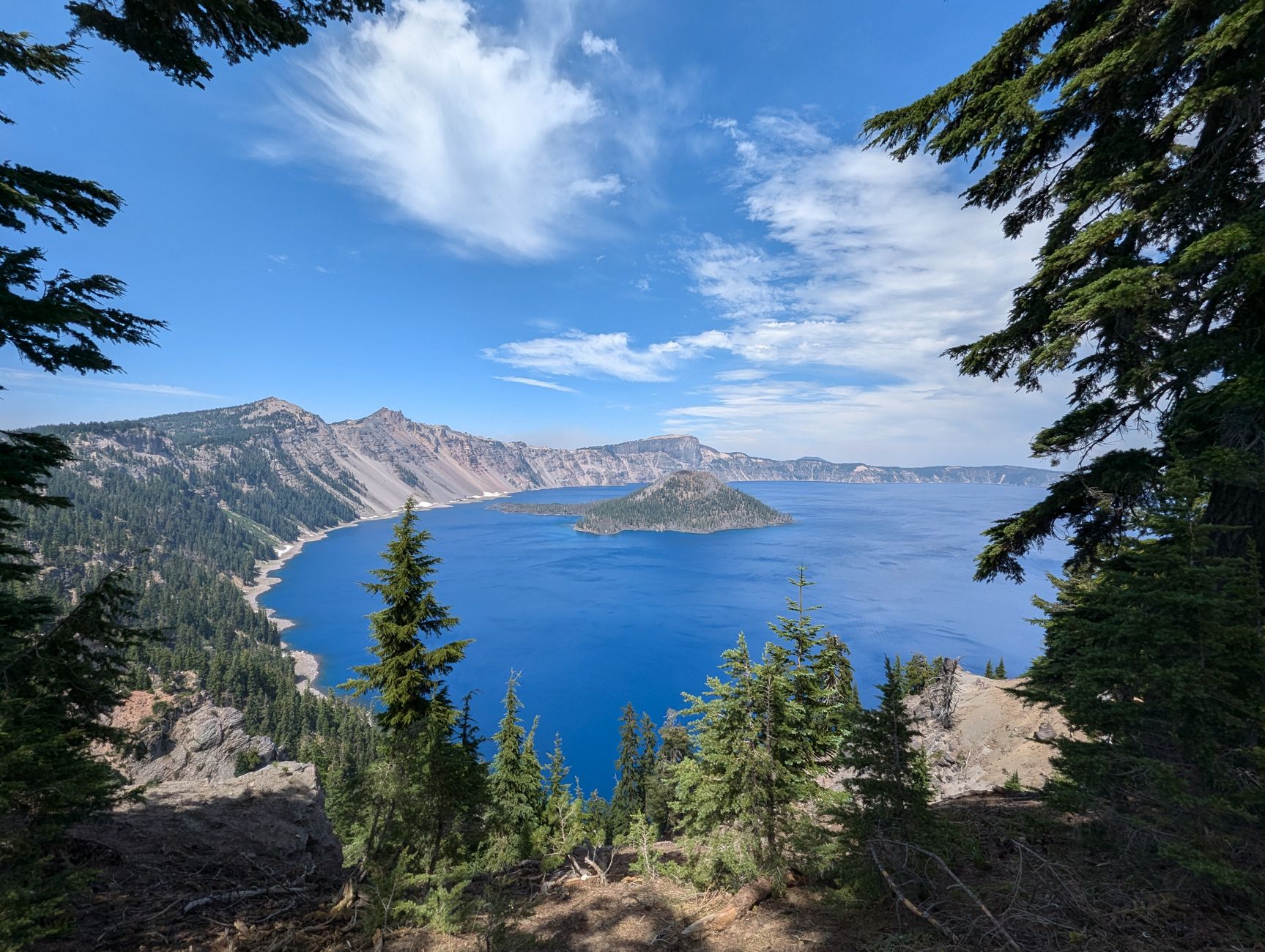 Breathtaking view of Crater Lake's deep blue waters surrounded by rugged cliffs and lush forests.
