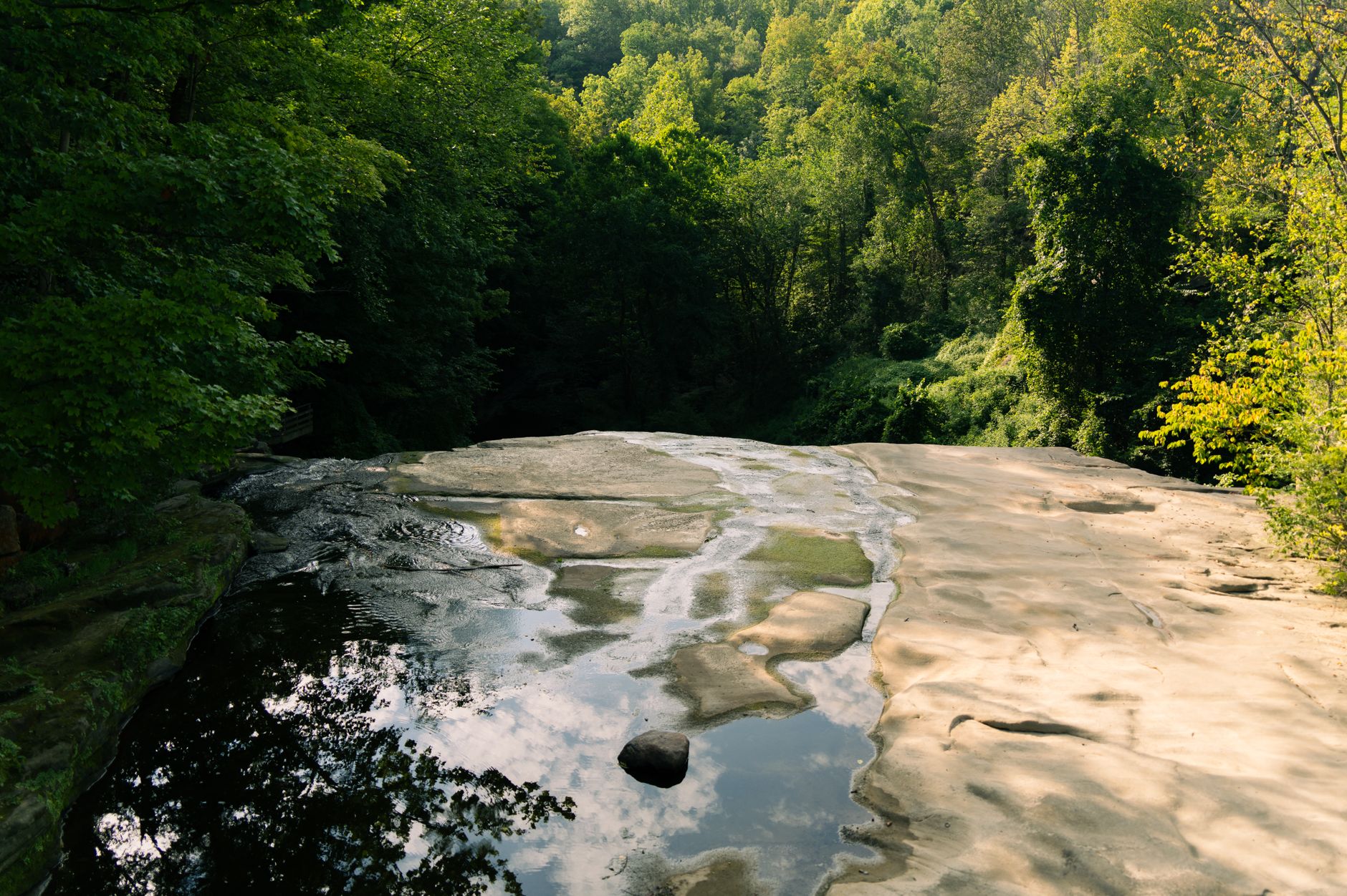 Tranquil view of a waterfall with lush forest backdrop at Cuyahoga Valley National Park in Ohio during summer.