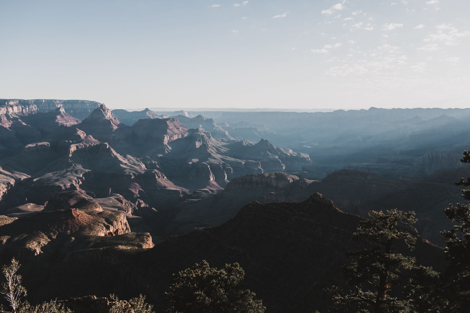 Scenic landscape of the Grand Canyon with early morning light casting shadows across the rocky formations.