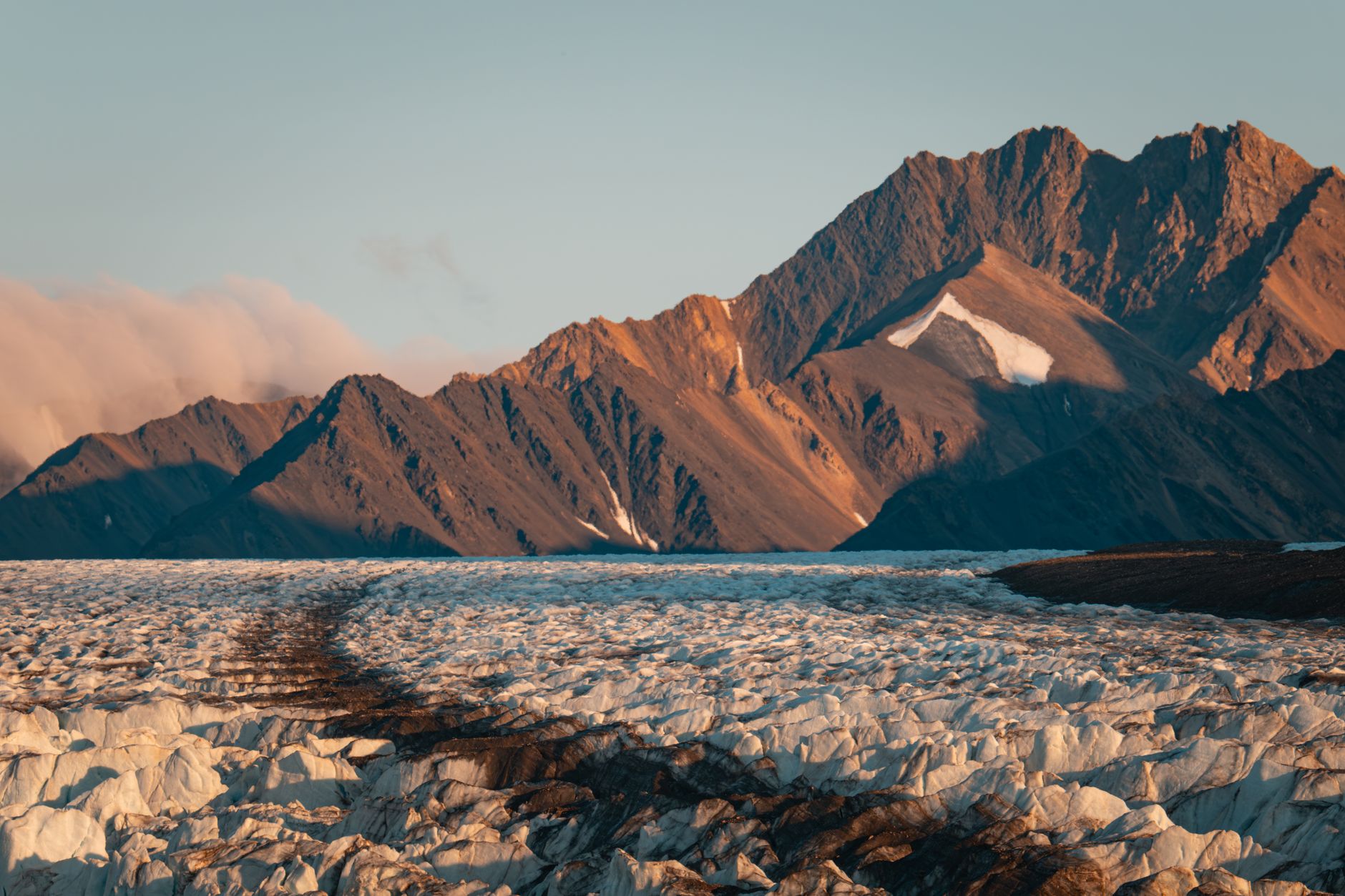 Dramatic glacial and mountain landscape captured during golden hour, showcasing breathtaking natural beauty.