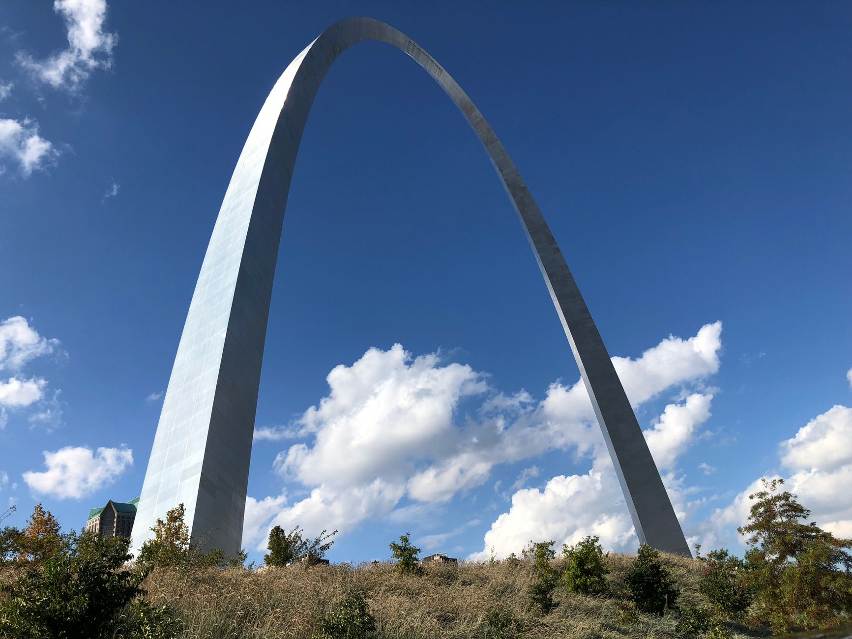 Stunning view of the Gateway Arch in St. Louis, Missouri, against a bright blue sky with clouds.