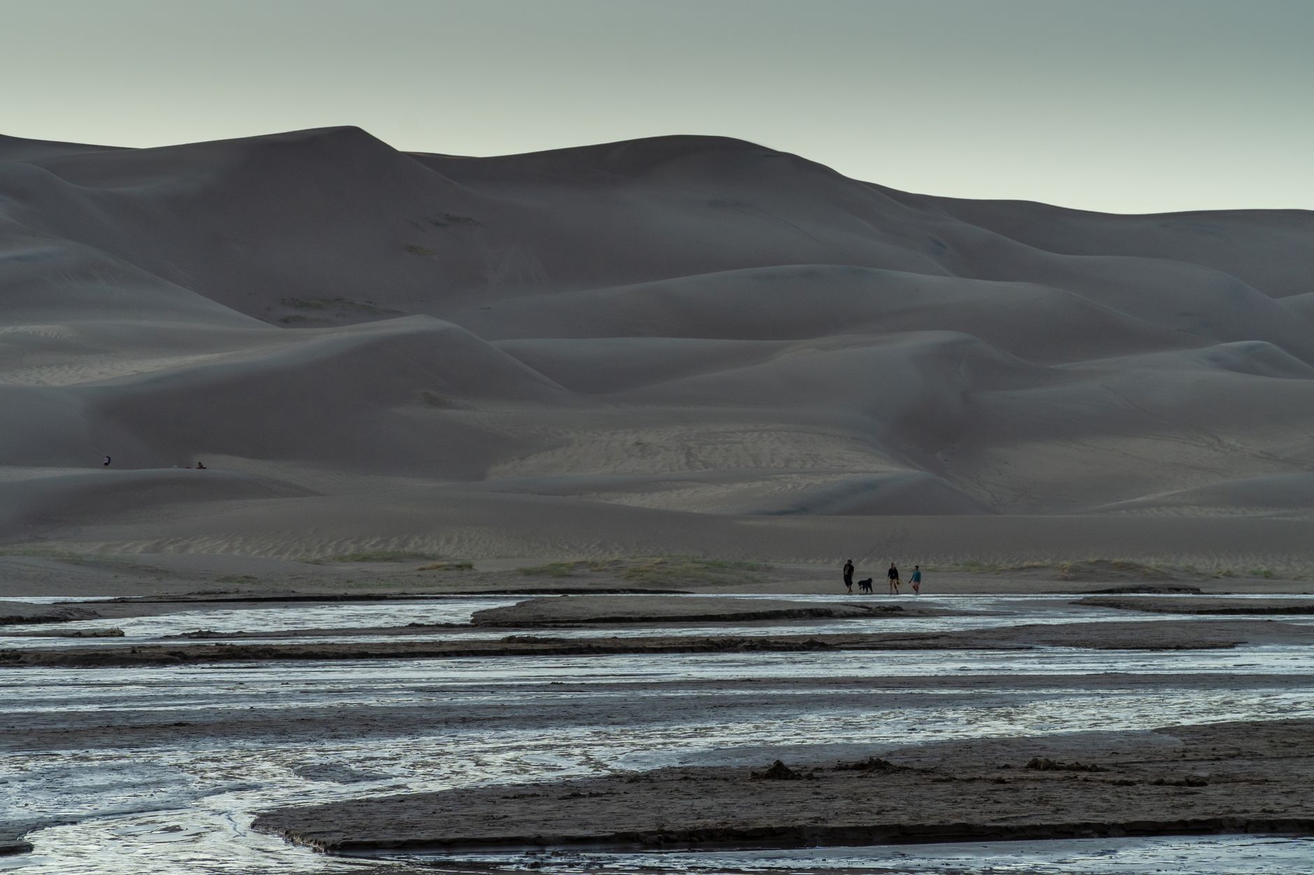 Hikers traverse the vast sand dunes at Great Sand Dunes National Park in Colorado.