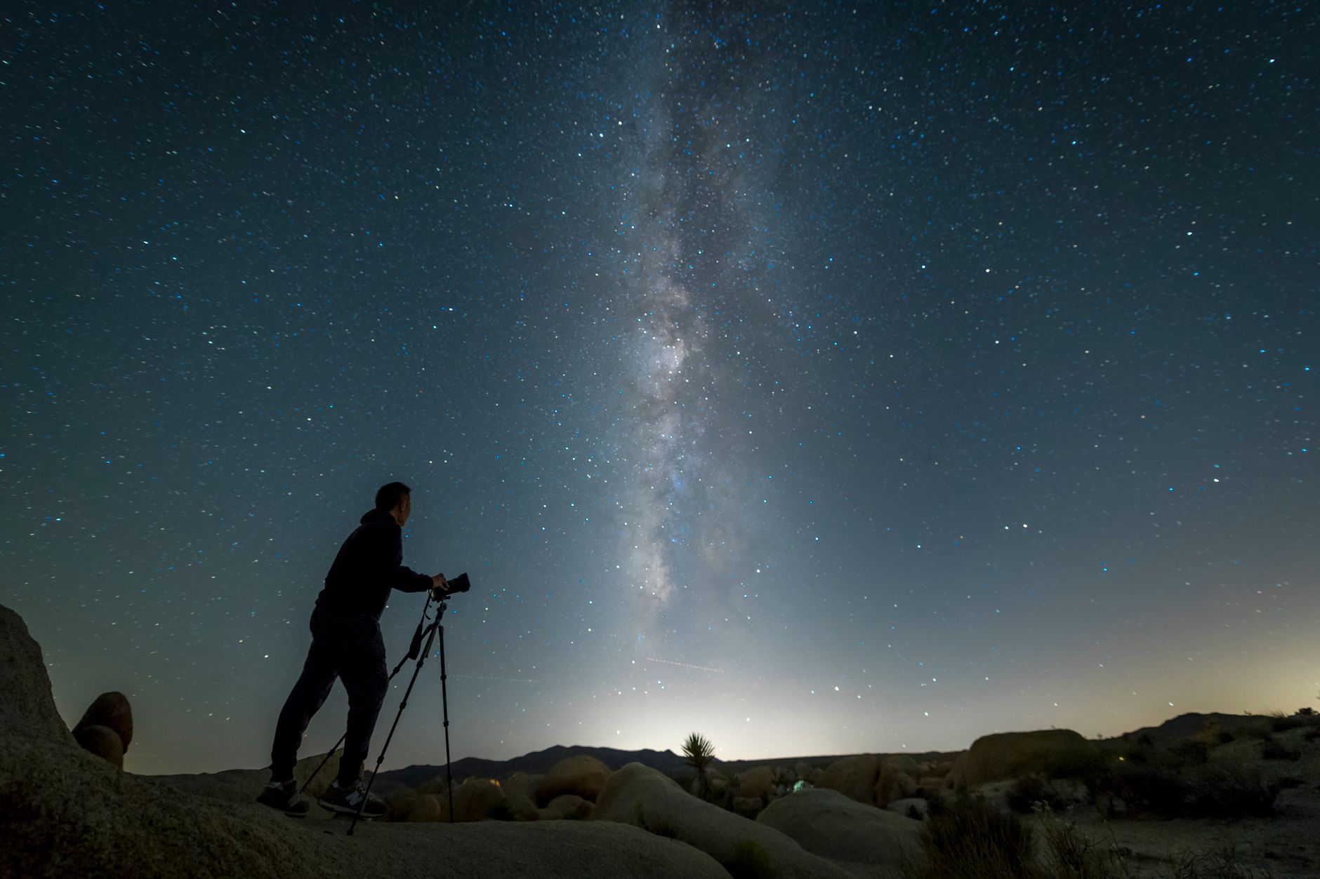 Photographer capturing the stunning Milky Way galaxy in a California desert night sky.