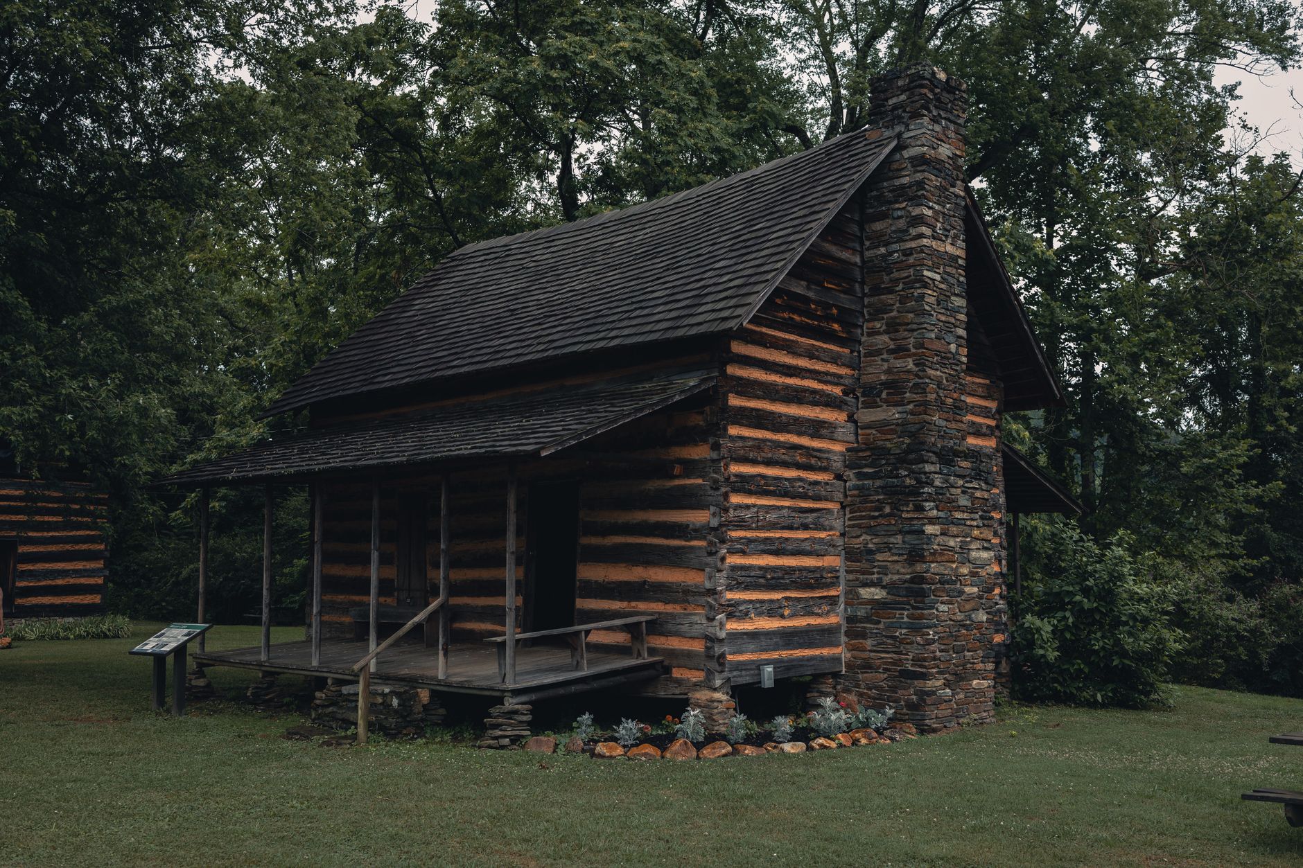 Charming historic log cabin surrounded by lush greenery in Gatlinburg, Tennessee, capturing rustic architecture.