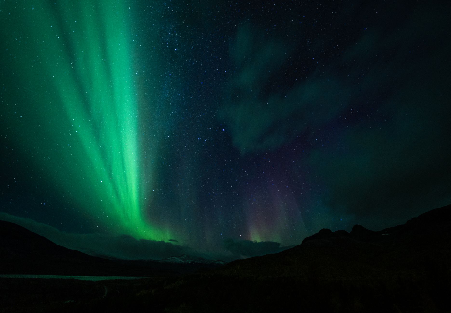 A stunning display of the aurora borealis illuminating the night sky with vibrant green and purple hues.
