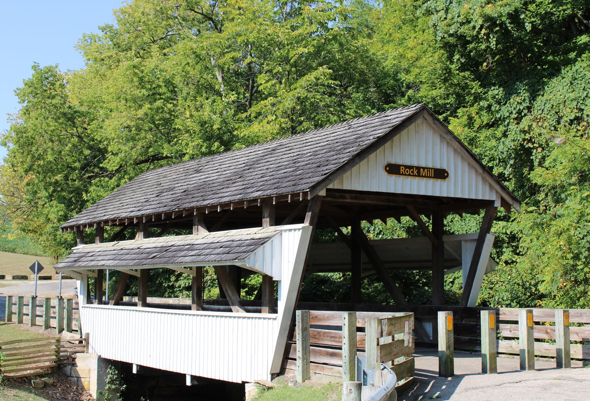 A rustic wooden covered bridge surrounded by lush green trees in Lancaster, Ohio.