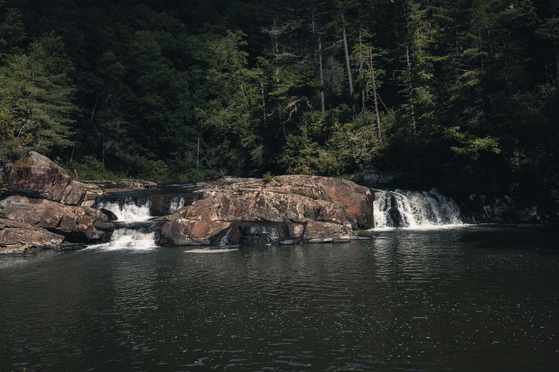 Tranquil waterfall surrounded by lush forest in Gatlinburg, ideal for nature lovers and travel enthusiasts.