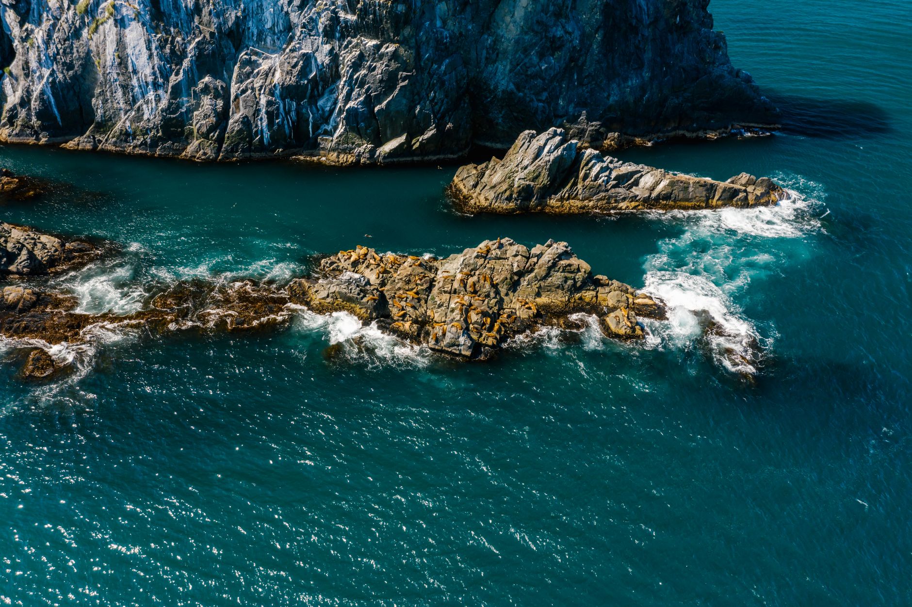 Stunning aerial photo of rugged rocky coastline meeting turquoise sea for a nature-inspired setting.