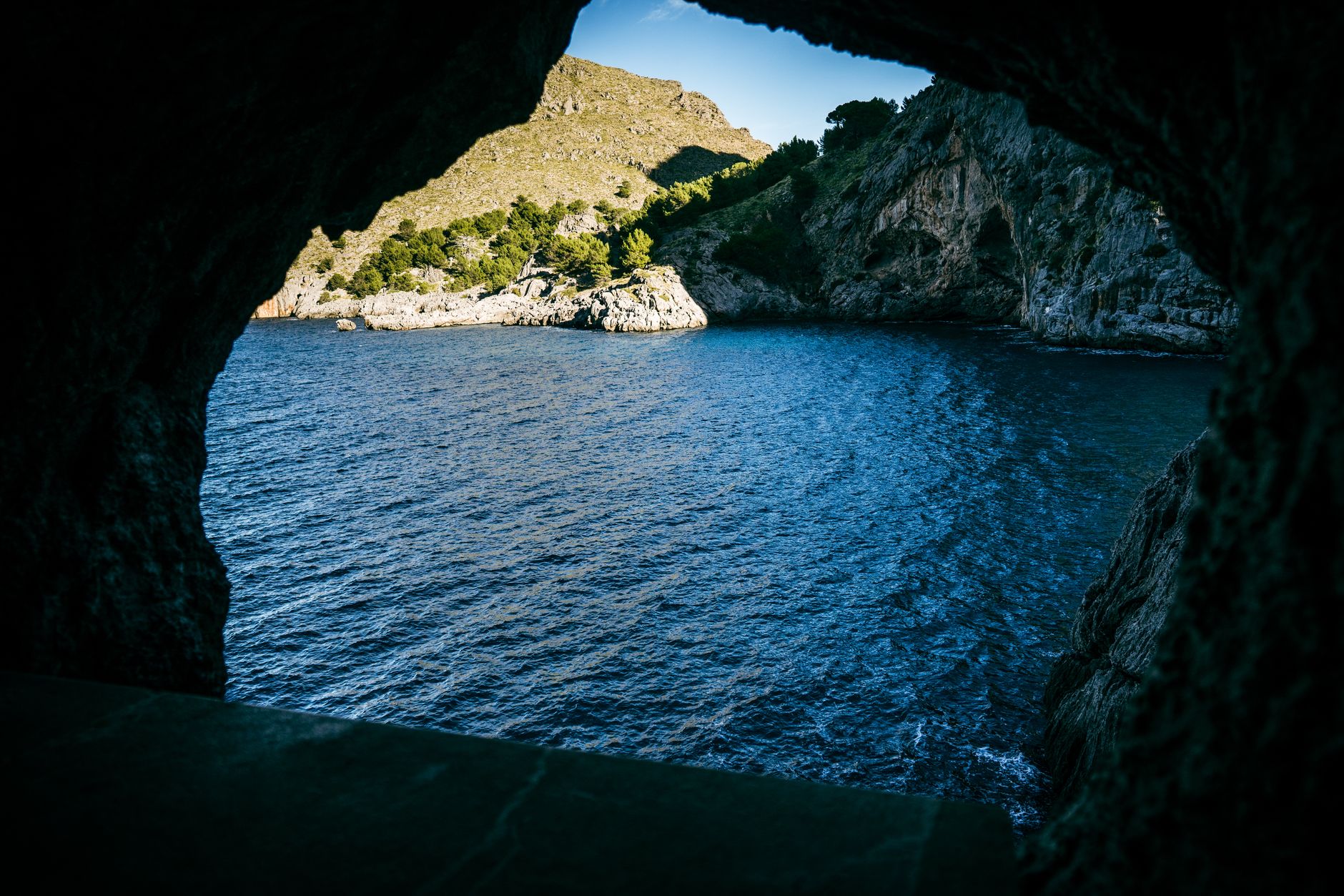 Breathtaking view of a rocky coastline with the sea visible through a natural cave opening.
