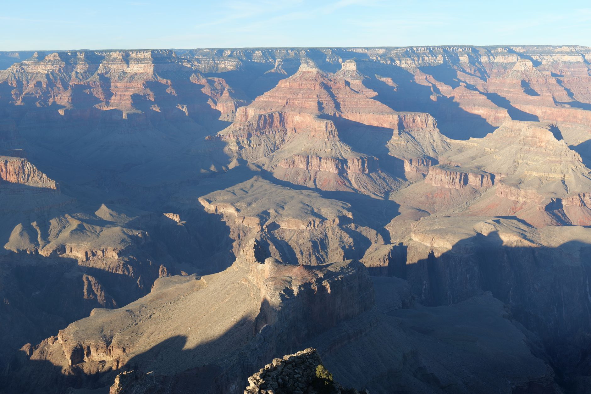 Majestic aerial view of the Grand Canyon's rugged terrain during sunset, showcasing vibrant rock layers.